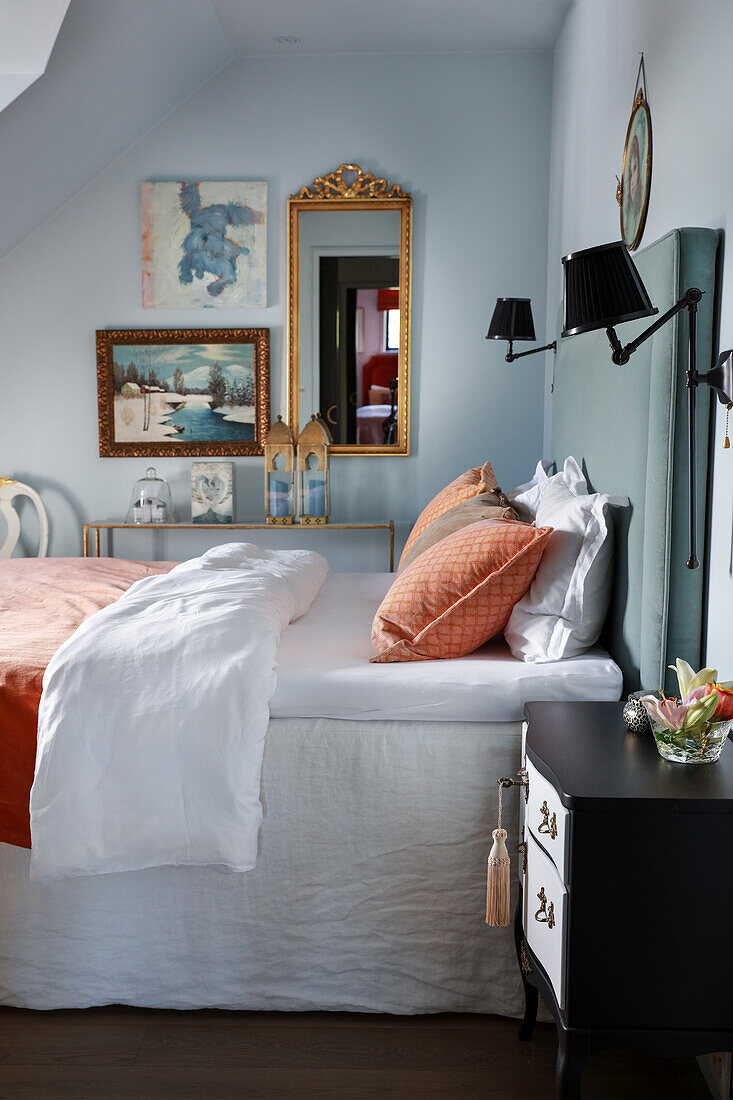 Doppelbett mit hohem Kopfteil und Kunstwerke an der Wand im Schlafzimmer