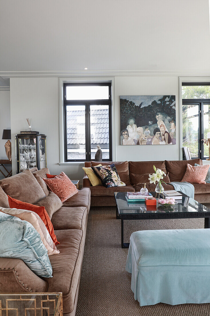 Sofas in shades of brown with scatter cushions and coffee table in lounge