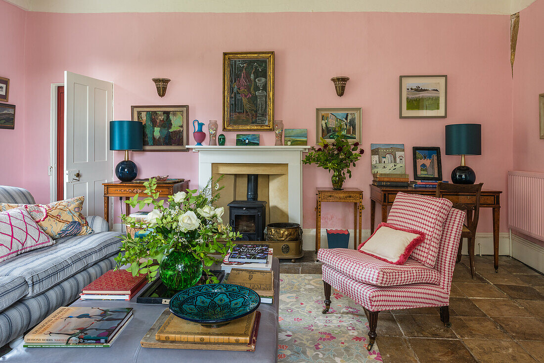 Couchtisch, Polstermöbel und Kamin im Wohnzimmer mit rosa Wänden