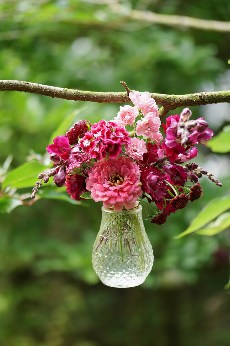 Small bouquet with zinnia, carnation, snapdragons, and florets in a hanging glass vase