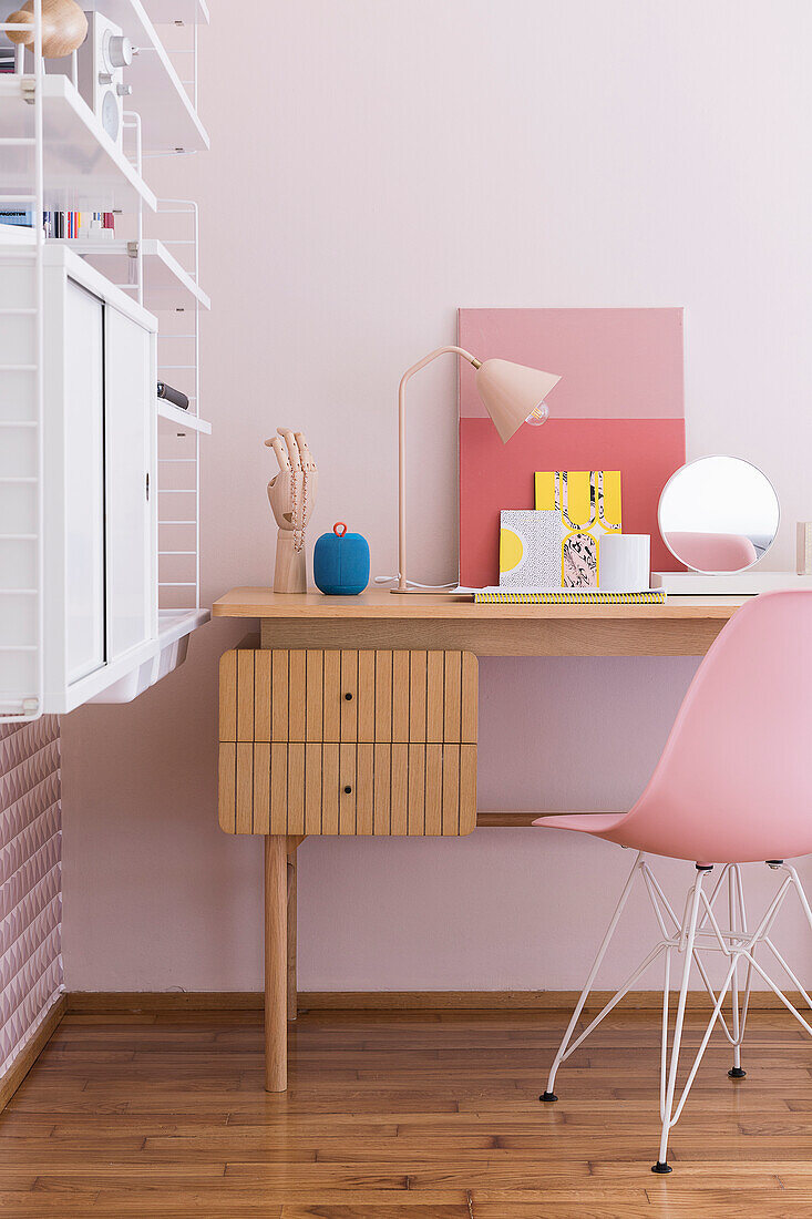 Schreibtisch mit Klassikerstuhl und Regal im Mädchenzimmer mit rosa Wand