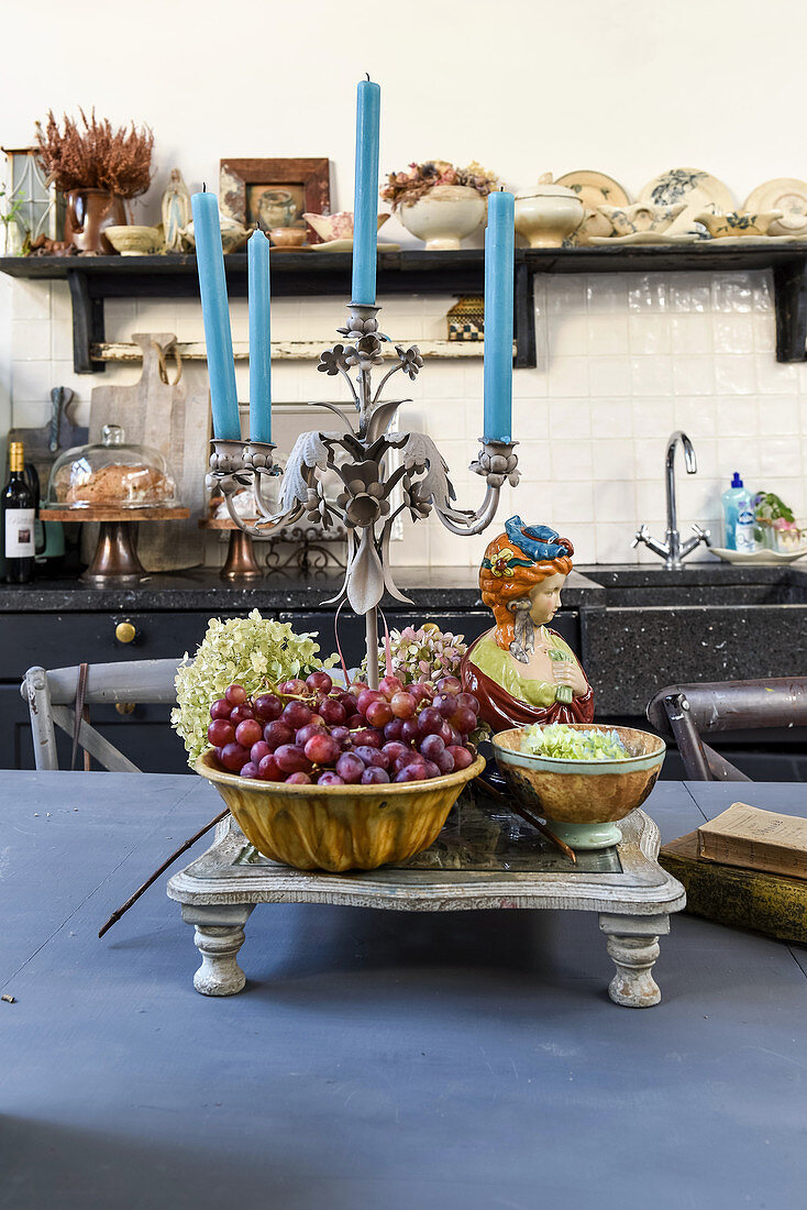 Vintage arrangement of grapes, bust and candelabra on kitchen table