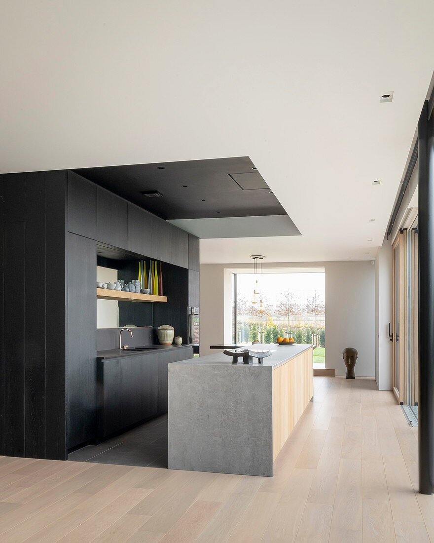 Modern kitchen in black and grey in open-plan interior