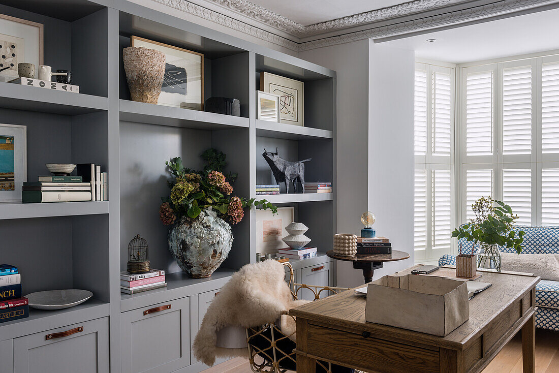 Grey cabinets with shelves and wooden desk in study