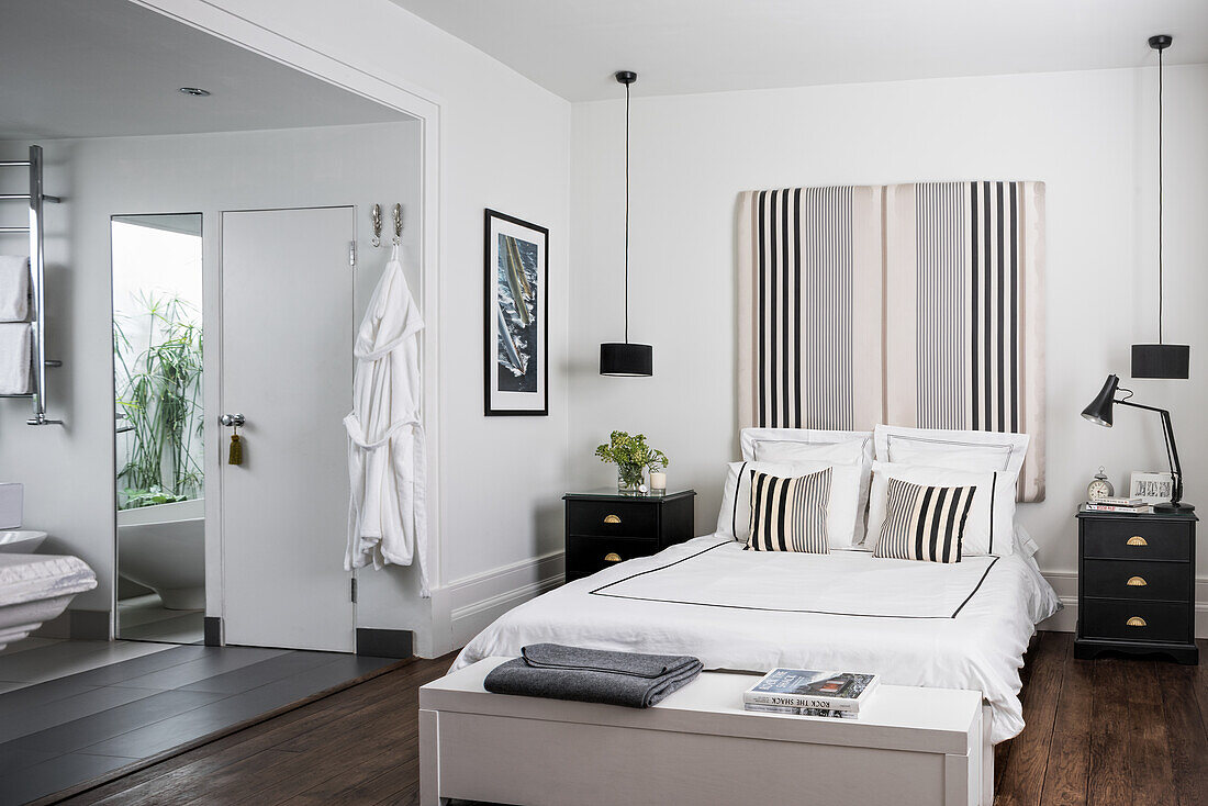 Striped bed headboard in masculine bedroom with ensuite bathroom