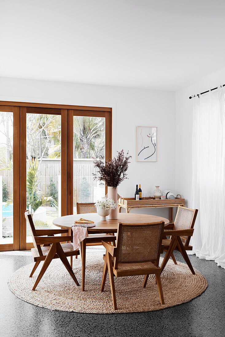 Chairs with Viennese weave around round table in front of patio door