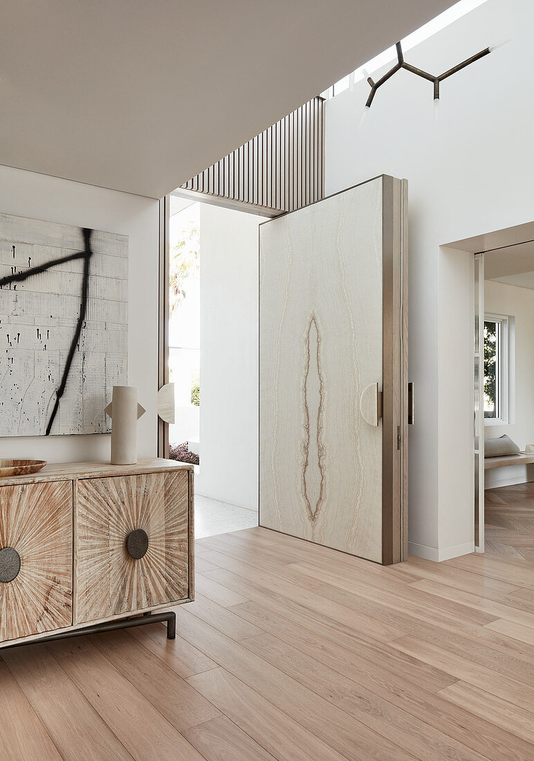 Modern, open front door in luxurious interior decorated in beige