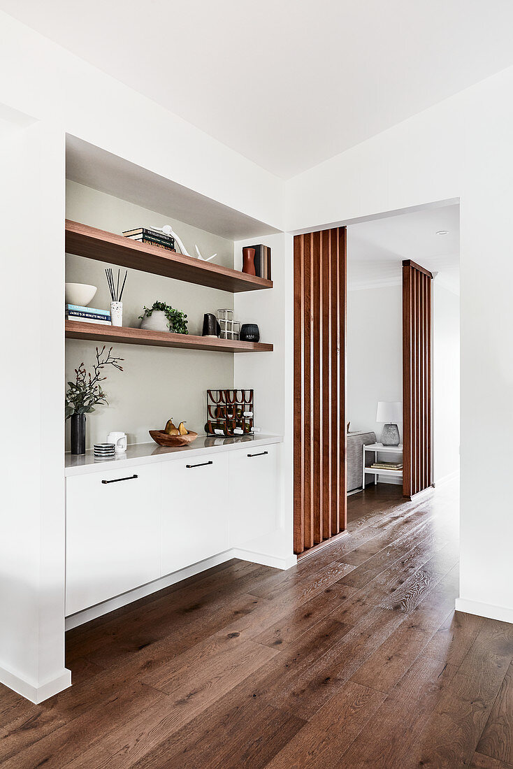 Sideboard and fitted shelves in niche in connecting room