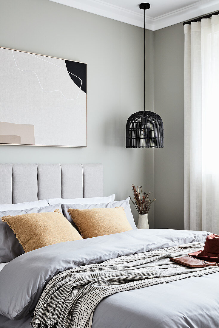 Delicate, muted shades in bedroom with pale grey walls