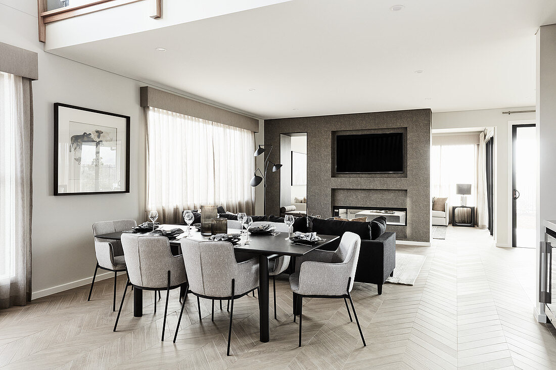 Luxuriöser offener Wohnraum in Grautönen mit gedecktem Tisch