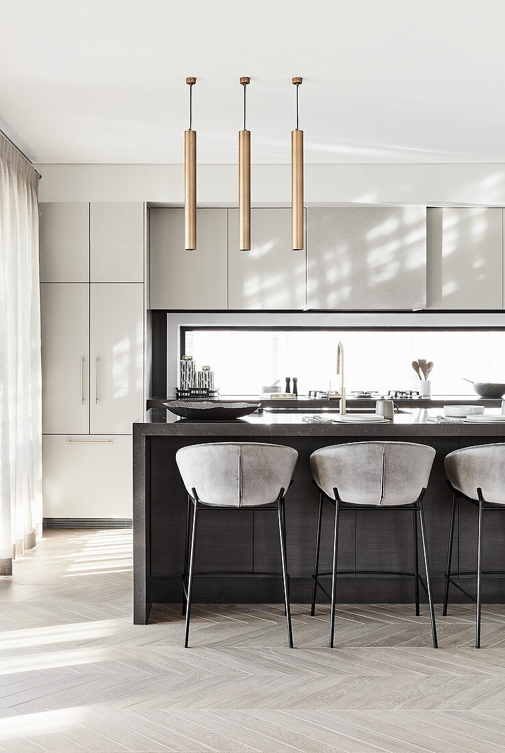 Upholstered bar stools at island counter in modern kitchen decorated in grey