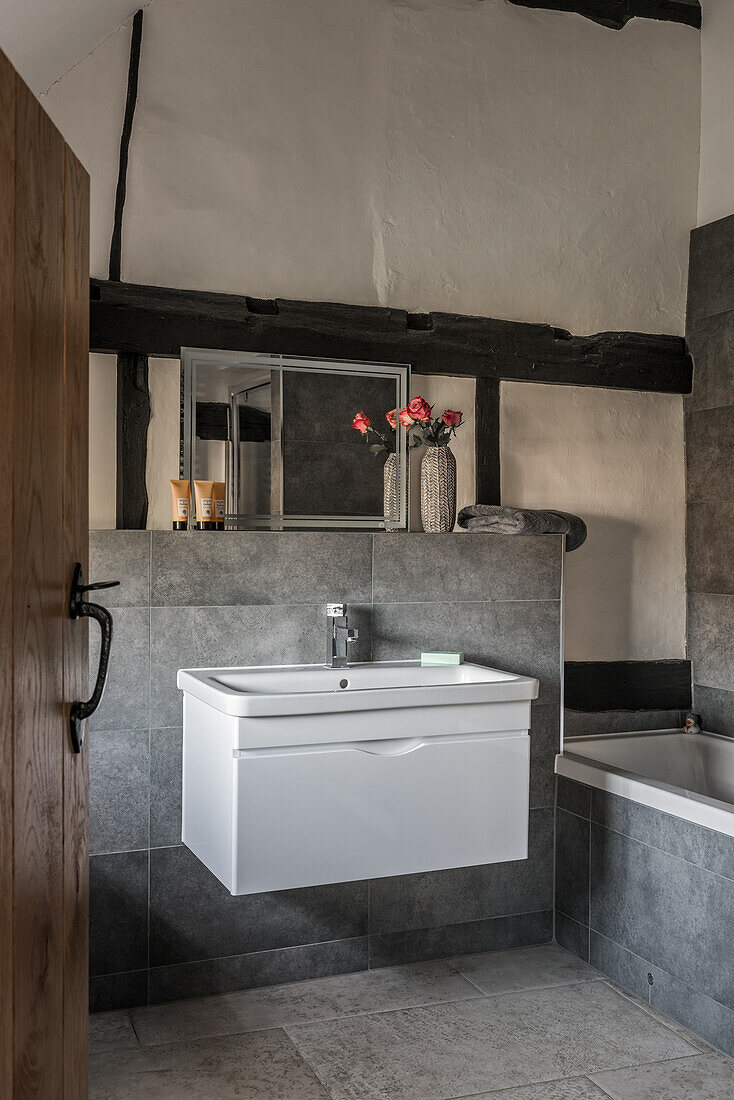 Uneven plastered walls contrasted by clean lines of contemporary basin unit