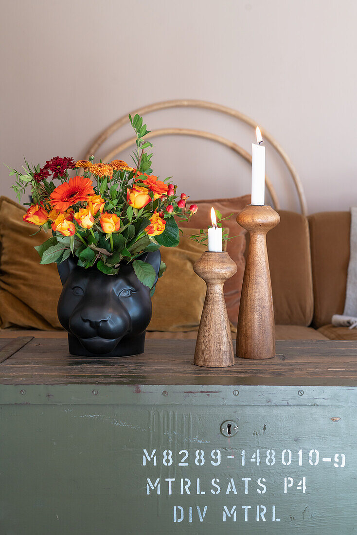 Vintage Holztruhe als Couchtisch mit Blumenstrauß und Kerzen