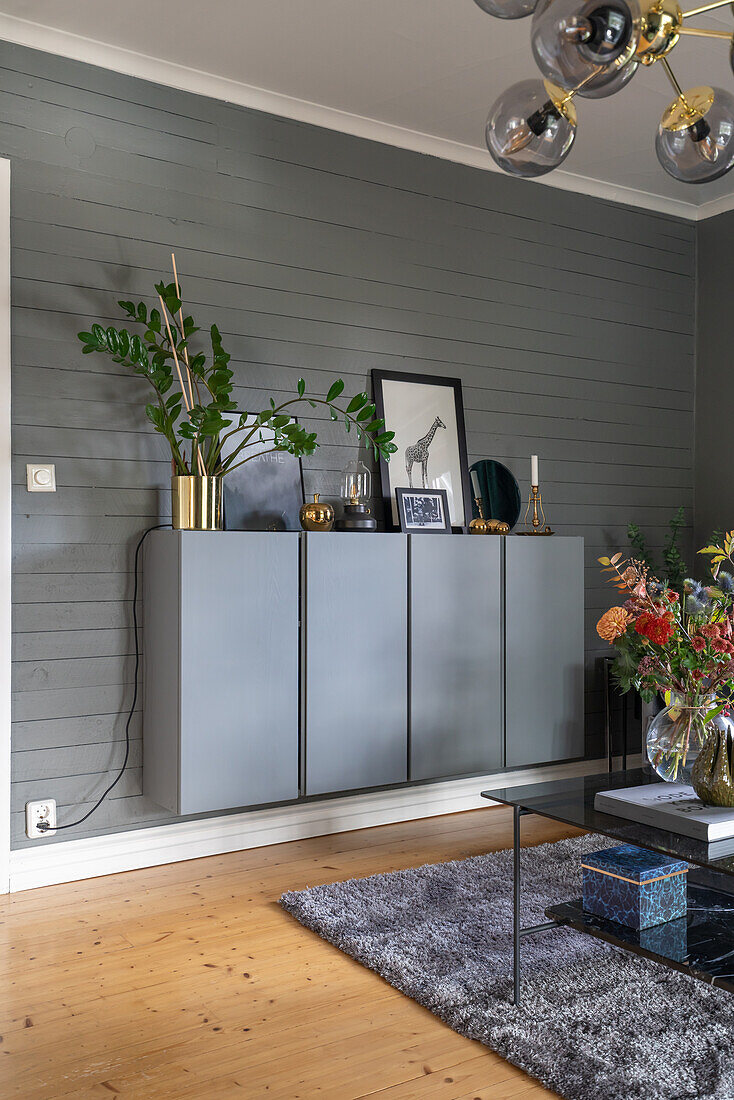 Grey wall mounted sideboard on wood paneled wall in the living room