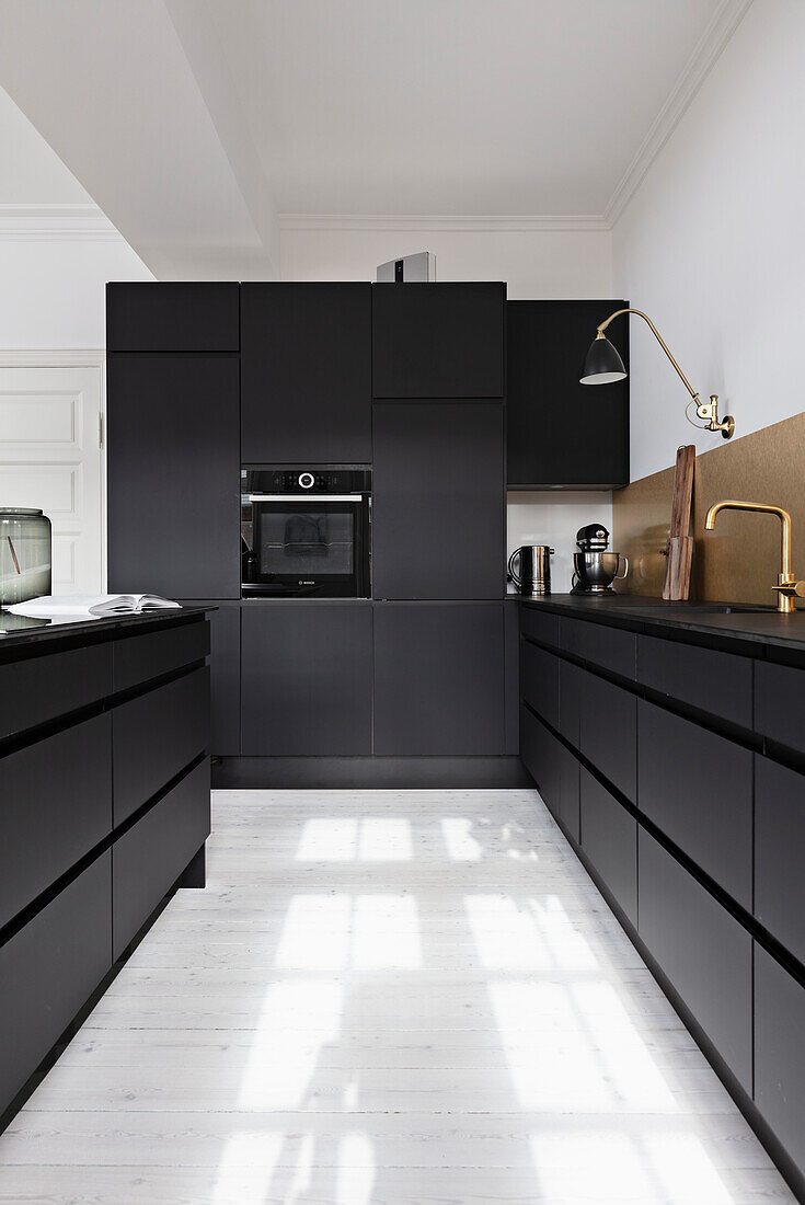 Moderne schwarze Küche mit weißem Dielenboden
