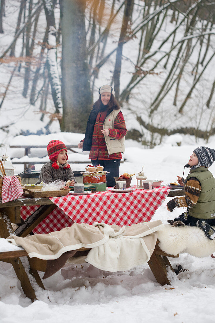 Picknick mit Kindern im verschneiten Wald