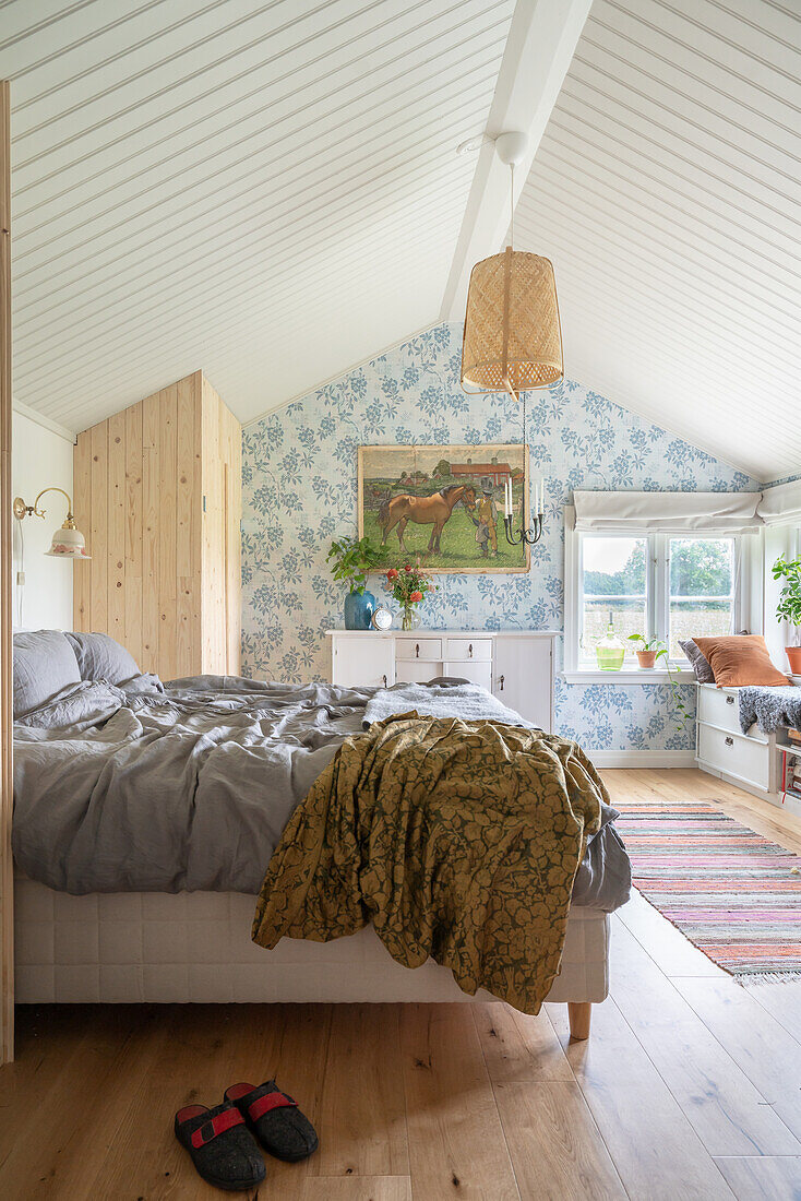 Doppelbett im Schlafzimmer mit weiß gestrichenem Giebeldach