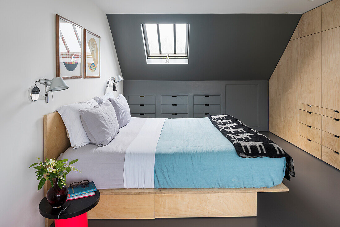 Doppelbett und eingebauter Stauraum in minimalistischem Schlafzimmer