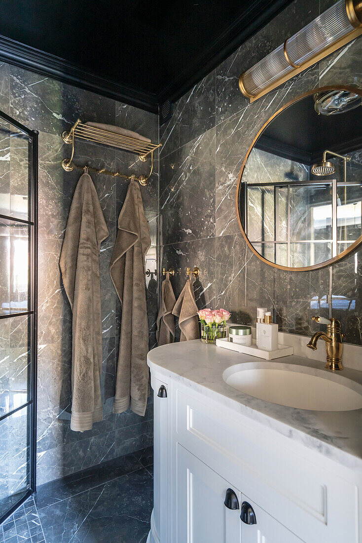 Vanity unit in the bathroom with a dark marble wall