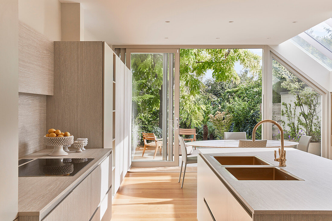 Bright kitchen with dining table in background next to open terrace door