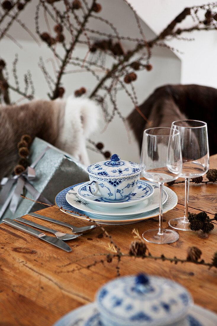 Blau-weiße Suppentassen mit Deckel an rustikalem Holztisch mit Weihnachtsdekoration