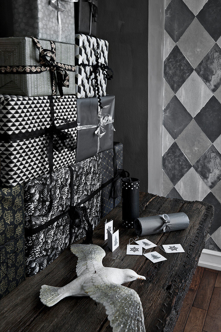 Geschenke-Turm in schwarz-weißer Verpackung und Möwenfigur auf Holztisch