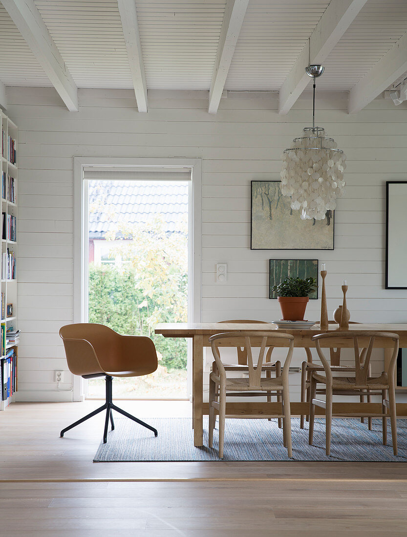 Esstisch im Zimmer mit weiß gestrichener Holzverkleidung