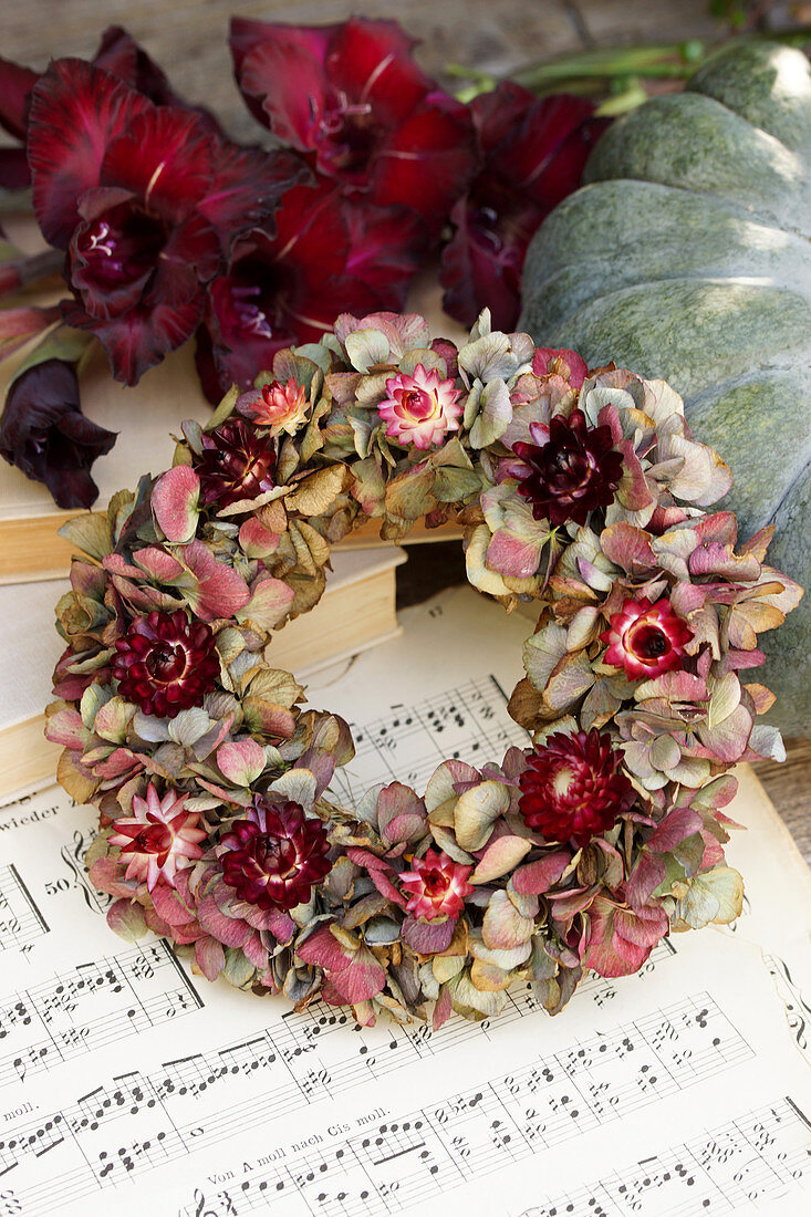 Wreath of hydrangea flowers and everlasting flowers on a pumpkin