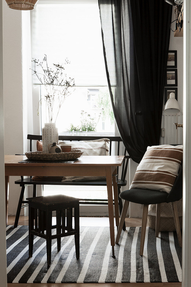 Wooden table and various seats in front of window
