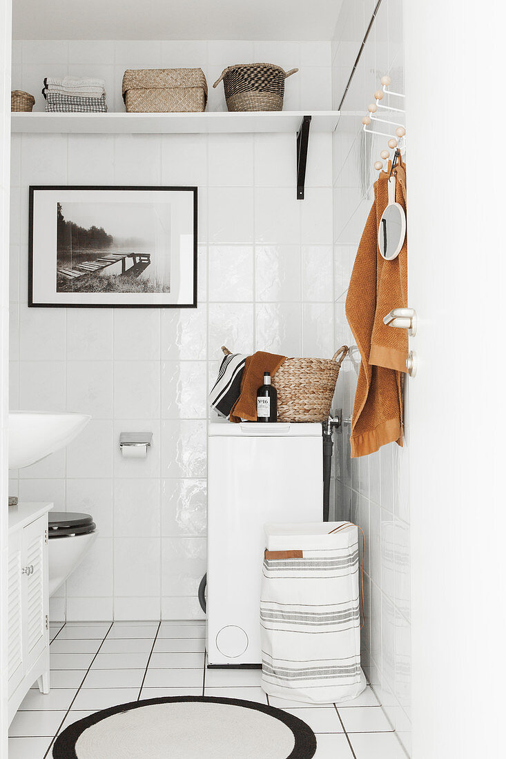 Weiß gefliestes Badezimmer mit Waschmaschine