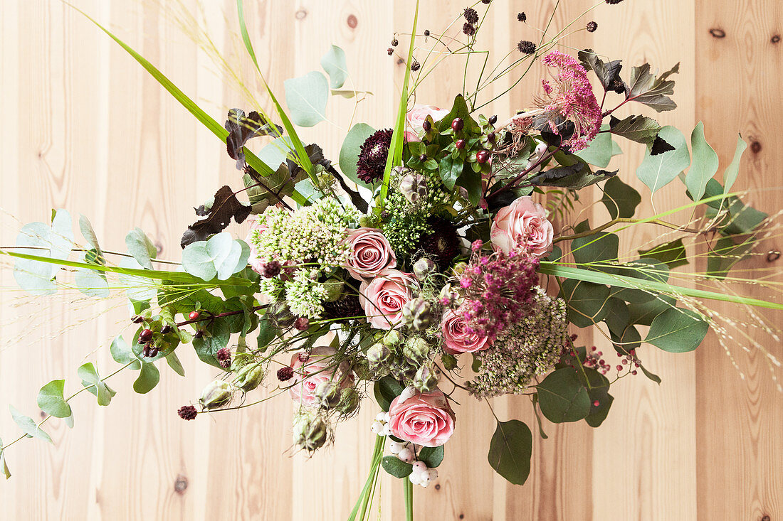 Autumn bouquet with roses, eucalyptus, love-in-a-mist seed heads, great burnet, sedum, pink pepper and chrysanthemums