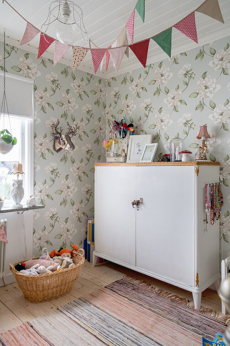 Alter Schrank im nostalgischen Kinderzimmer mit Blumentapete