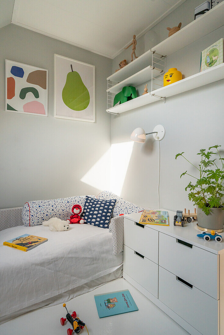 Bright children's room with bed, drawers, and shelves