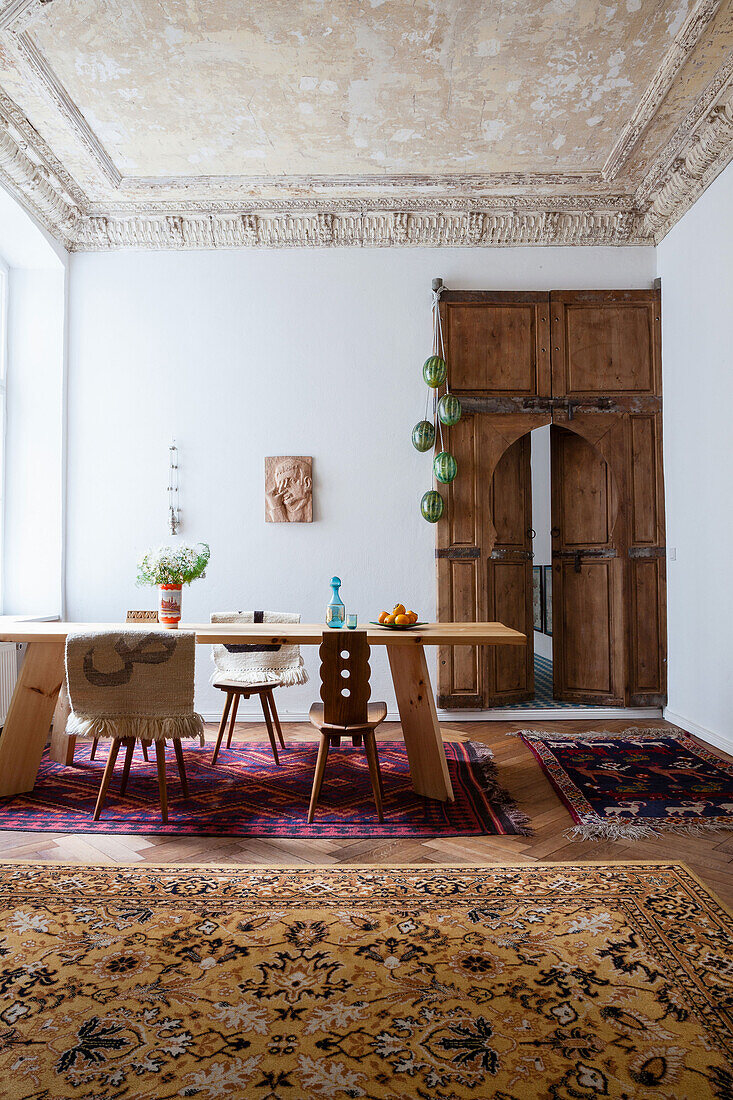 Holztisch mit Holzstühlen im Esszimmer mit marokkanischer Tür