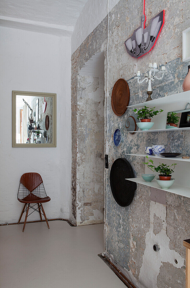 Rustic wall with patina and modern wall shelves in an old building