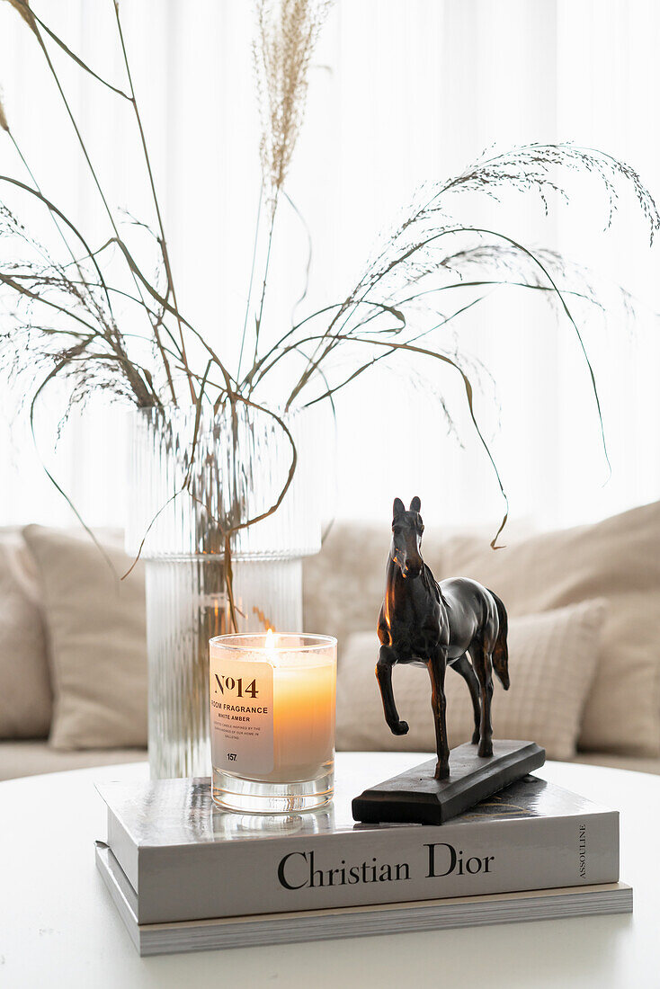 Coffee table with vase, books, candle, and horse figurine