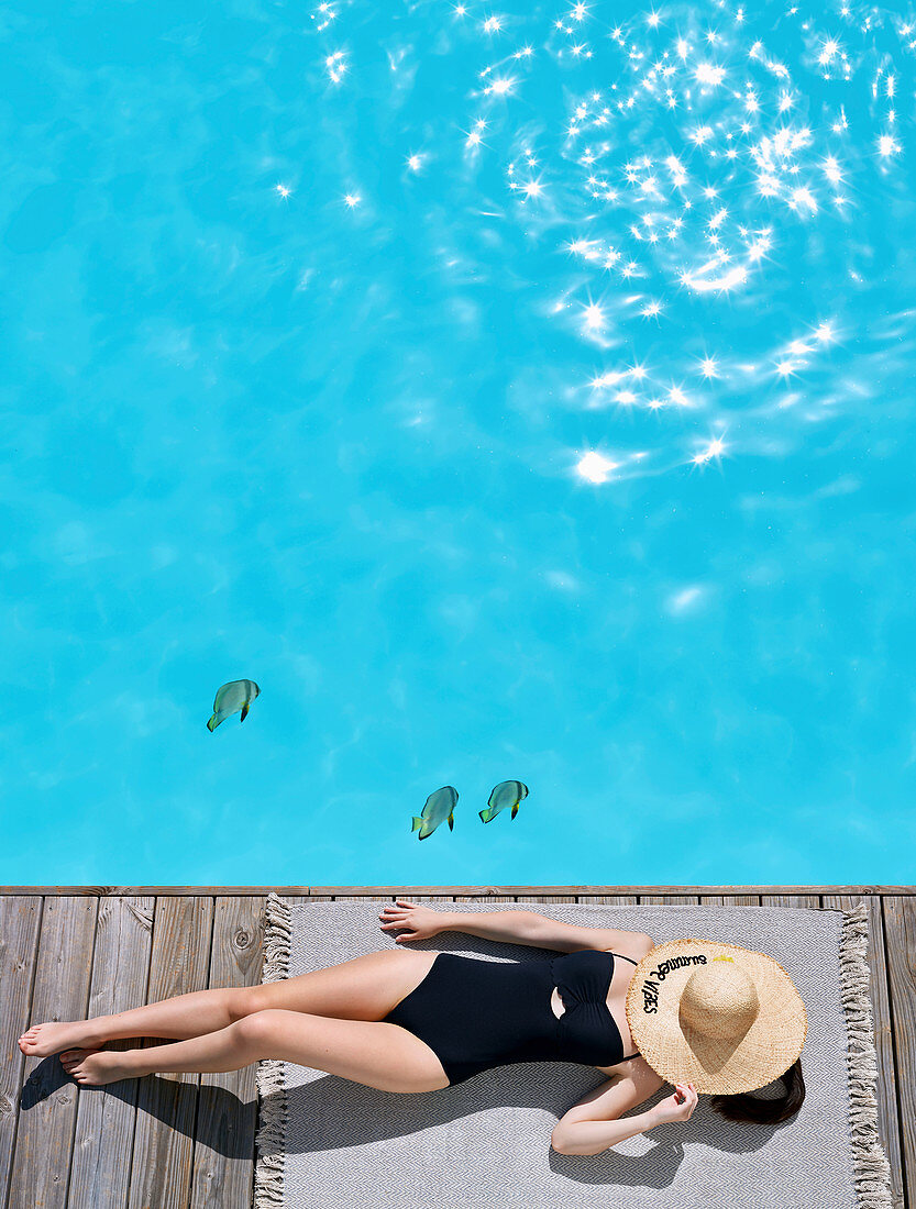 Frau im Badeanzug am Poolrand liegend, Gesicht mit Strohhut verdeckt