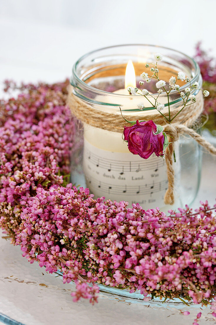 Candle lantern in wreath of heather decorated with rose and gypsophila