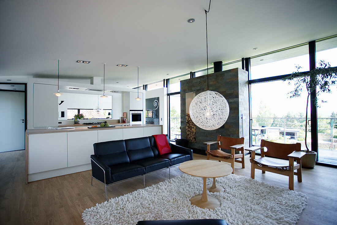 Kitchen and seating area in open-plan interior with glass wall