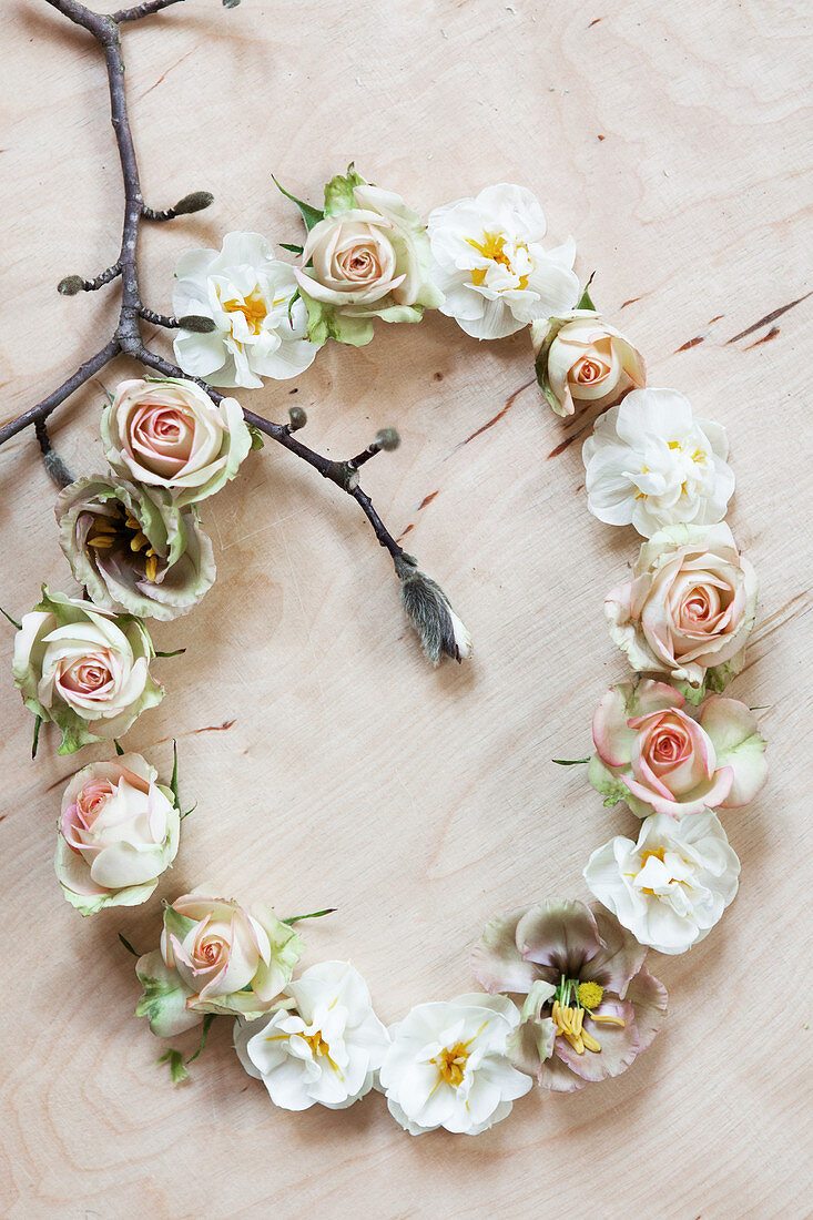 Liegender Blütenkranz mit Rosenblüten, Narzissenblüten und Magnolienzweig
