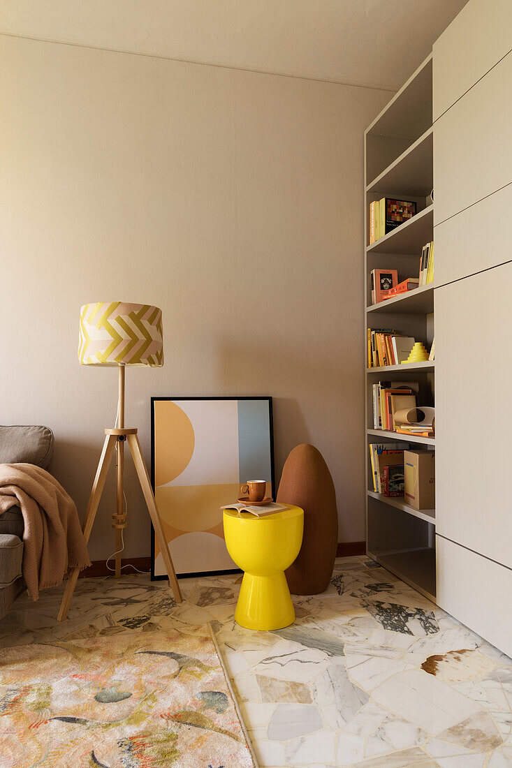 Shelving cabinet, yellow stool, and floor lamp in living room
