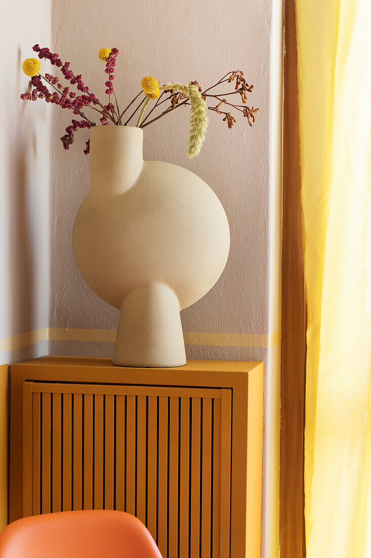 Ceramic flower vase on radiator cover