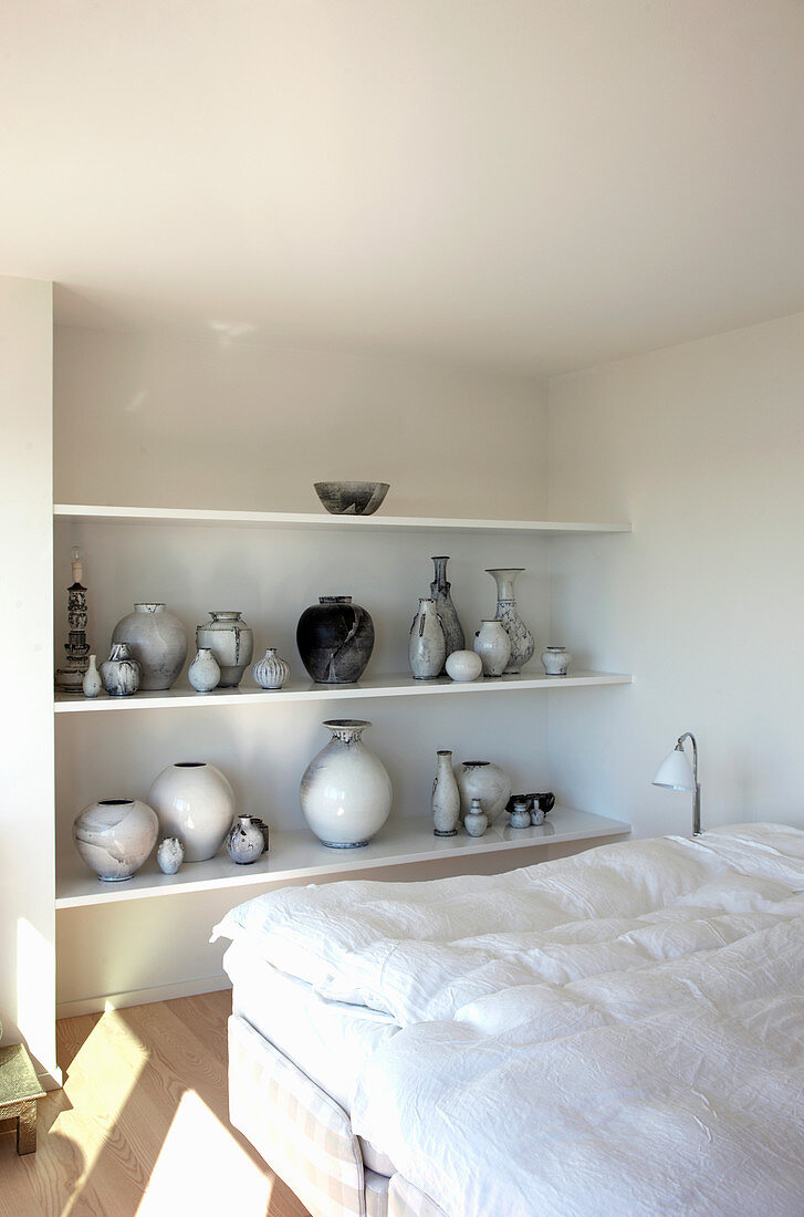 Collection of vases on shelves in bedroom
