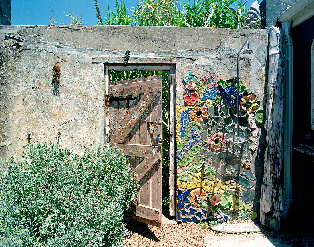 Artistically decorated stone wall with outdoor shower