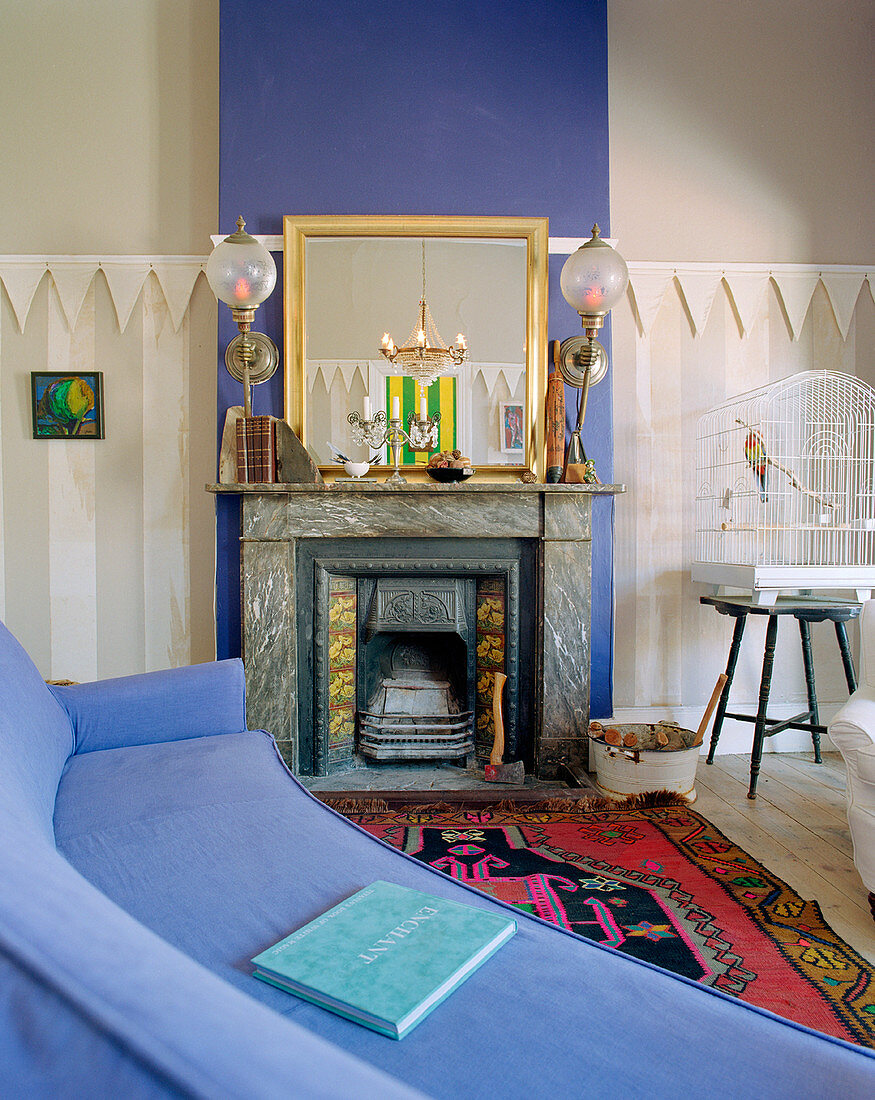 Blaue Couch vor Kamin mit blauer Wand im Wohnzimmer