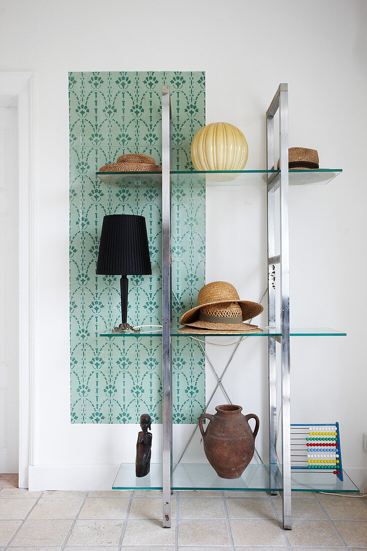 Hats, table lamps and urn on glass shelves
