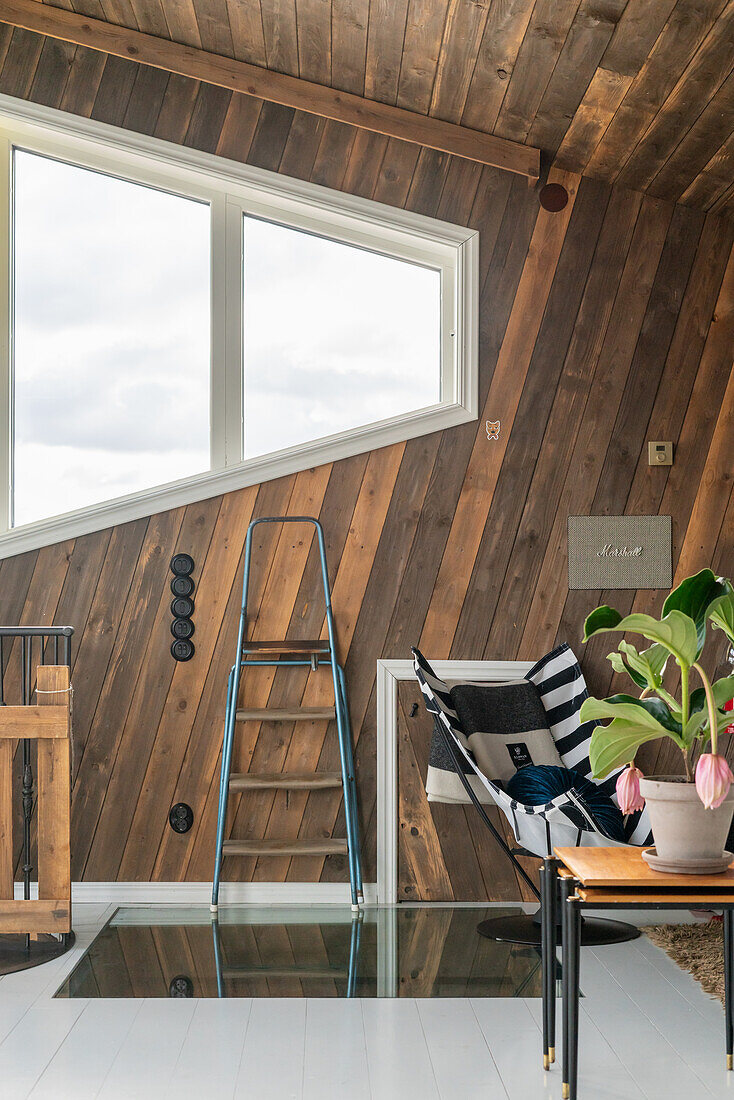 Zimmer mit rustikaler Holzverkleidung und Boden mit Glaseinsatz