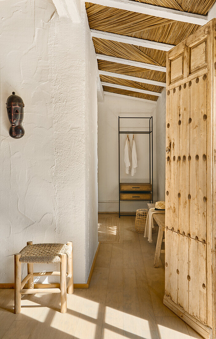 Light-flooded room with white walls and reed ceiling