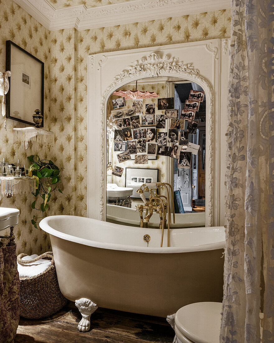 Vintage clawfoot bathtub, mirror and wallpaper in bathroom
