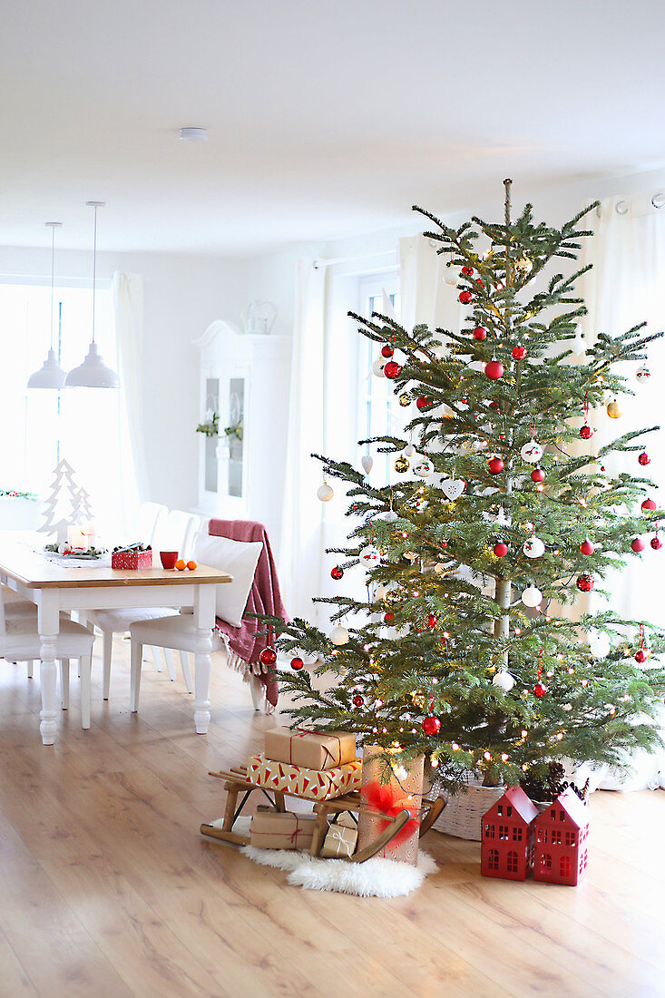 Weihnachtsbaum, darunter Geschenke vor Esstisch